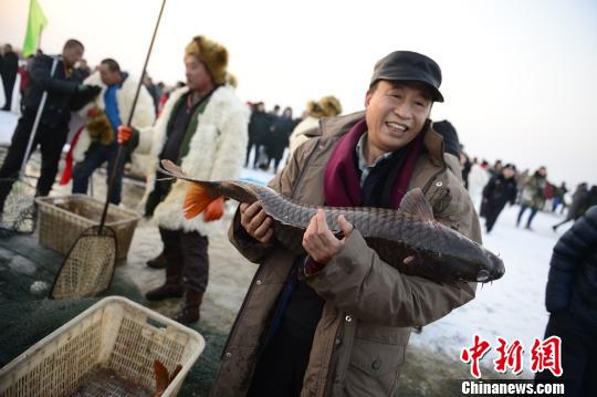 图为民众与冬捕头鱼合影 刘文华 摄 图为民众与冬捕头鱼合影 刘文华 摄